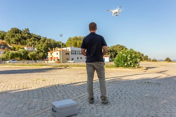 İnsan, bir mühendis pilot, bir dron, bir vileo ve fotoğrafı test etmek ve filme almak için kalkış için hava aygıtı hazırlar. Kumandayı kontrol ederek.
