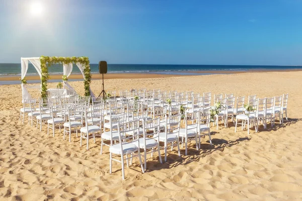 Romantische Aussicht und Blumenschmuck am Strand in der Nähe des Meeres, für eine Hochzeitszeremonie mit Blumen. Europa, Portugal, im Hintergrund der strahlenden Sonne. — Stockfoto