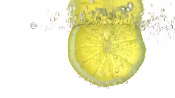 Konsep kesegaran, sepotong lemon dalam air jernih, dengan gelembung gas menyegarkan, close-up. Citrus minuman. — Stok Video