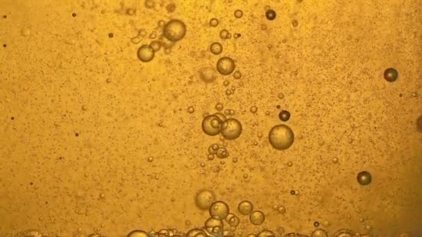 Bränsle, olja, gul gyllene nyans, med rörliga bubblor, upp och ner, i laboratoriets glaskärl. Kopiera utrymme. — Stockvideo