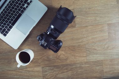 DSLR fotoğraf makinesi ile ahşap masa üstünde laptop