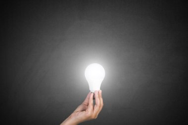 Ampul yazı tahtası üzerinde tutan el