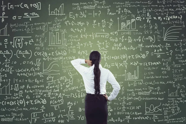 Portrait of businesswoman standing in front of blackboard — Stock Photo, Image