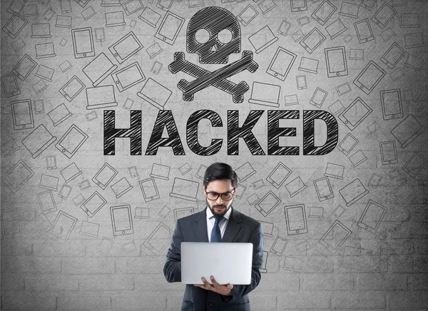 Empresario usando portátil delante del símbolo hackeado —  Fotos de Stock
