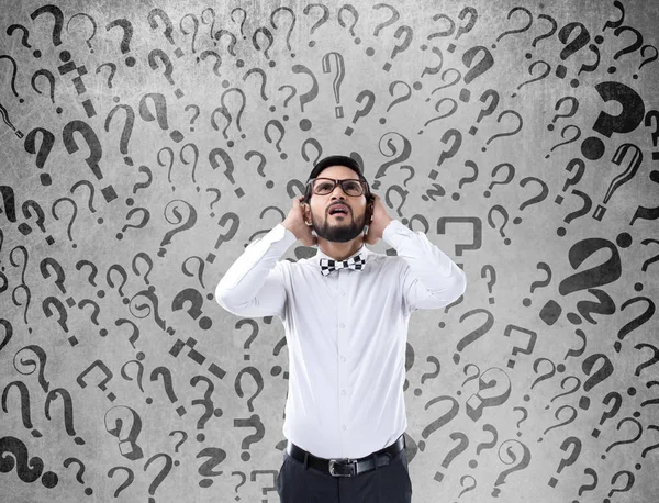 Shocked businessman with question marks — Stock Photo, Image