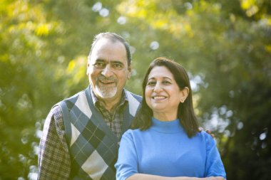 Park 'ta gülümseyen yaşlı çift portresi.