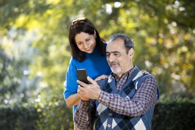Üst düzey kadın cep telefonu kullanarak kocasıyla medya içeriğini paylaşıyor