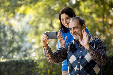 Üst düzey kadın cep telefonu kullanarak kocasıyla medya içeriğini paylaşıyor