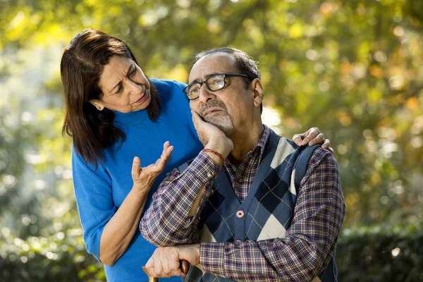 Yaşlı kadın parkta depresyondan kocasını teselli ediyor.