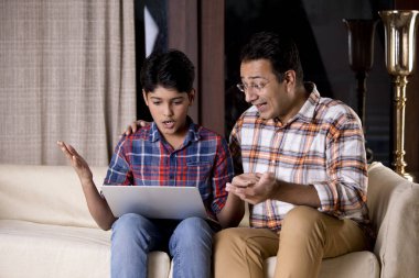 Baba ve oğul dizüstü bilgisayar kullanarak iyi haberler almalarına hayret ettiler.