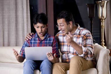 Baba ve oğul dizüstü bilgisayar kullanarak iyi haberler almalarına hayret ettiler.