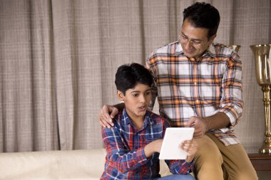 Baba ve oğul dijital tablet kullanarak iyi haberler almalarına hayret ettiler.