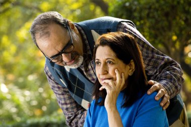 Adam parkta yaşlı kadını teselli ediyor.