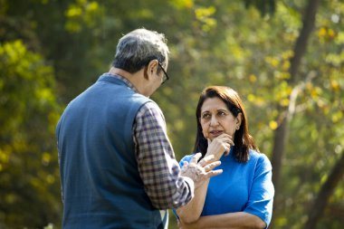 Yaşlı çift parkta tartışıyor.