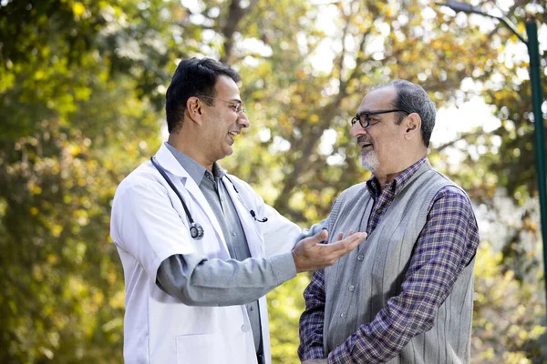 Doktor, hastane bahçesinde kıdemli bir adamla konuşuyor.