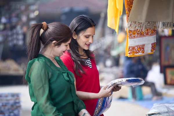 Two women shopping for dress at street market — 스톡 사진