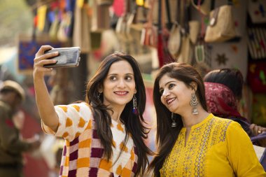 Two women taking selfie at Surajkund Mela