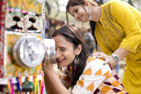 Women looking into bioscope at Surajkund Mela — стокове фото