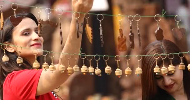 Two women shopping for necklace and earrings at street market — Αρχείο Βίντεο