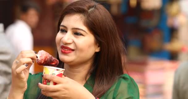 One women eating flavored ice gola dipped in syrup — Wideo stockowe