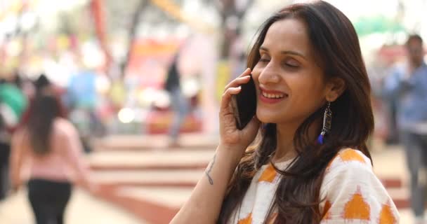 Happy woman talking on mobile phone at market — Stockvideo