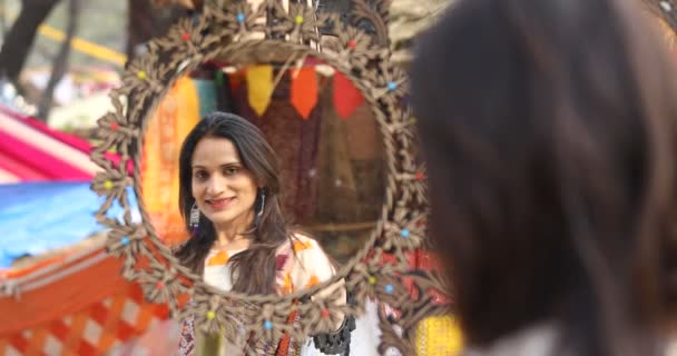 Woman looking into vintage mirror at Surajkund Mela — 图库视频影像
