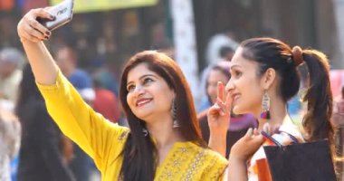 Two women taking selfie at Surajkund Mela