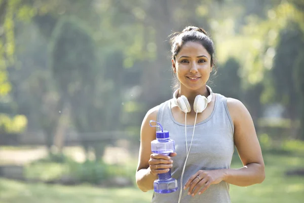 Fit mujer en ropa deportiva mirando a la cámara en el parque al aire libre — Foto de Stock