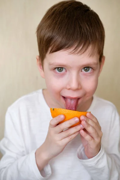 Yakışıklı çocuk portakalı yalıyor.