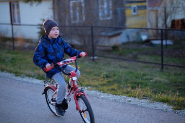 Çocuk gün batımında bisiklet sürüyor meltemle