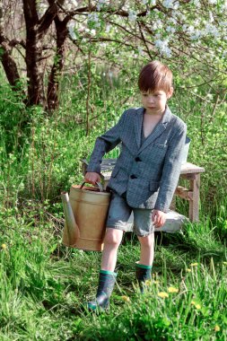 Bahçesinde su kovası olan bir çocuk.