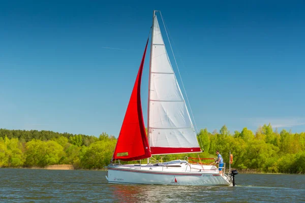 Yacht with red and white sail Stock Photo