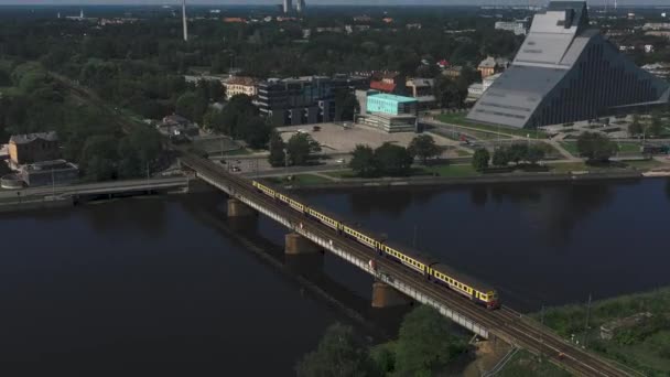 Riga, Letonya - Mayıs 2019: Güneşli bir günde şehir merkezindeki Daugava nehri üzerindeki köprünün insansız hava aracı görüntüsü. — Stok video