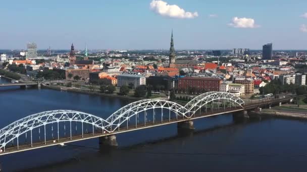 Riga, Lotyšsko - květen, 2019: Letecké video s panoramatickým výhledem na železniční most přes řeku a centrum Rigy. — Stock video