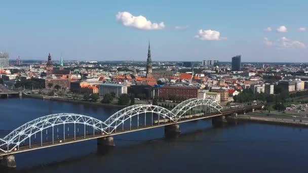 Riga, Lotyšsko - květen, 2019: Letecké video s panoramatickým výhledem na železniční most přes řeku a centrum Rigy. — Stock video