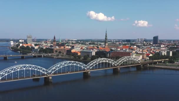 Riga, Lotyšsko - květen, 2019: Letecké video s panoramatickým výhledem na železniční most přes řeku a centrum Rigy. — Stock video