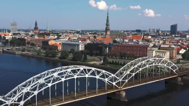 Riga, Lettland - Mai 2019: Luftbild mit Panoramablick auf die Eisenbahnbrücke über einen Fluss und das Stadtzentrum von Riga. — Stockvideo