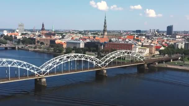 Riga, Lotyšsko - květen, 2019: Letecké video s panoramatickým výhledem na železniční most přes řeku a centrum Rigy. — Stock video