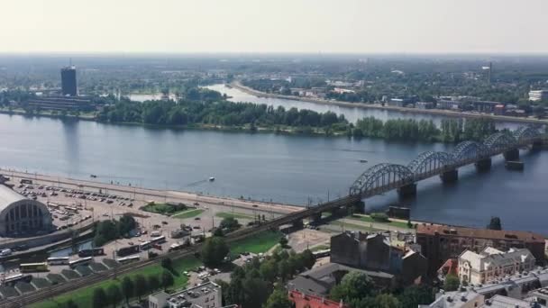 RIGA, LATVIA - MAIO, 2019: Vista aérea de drones do mercado central e ponte ferroviária que atravessa o rio Daugava . — Vídeo de Stock