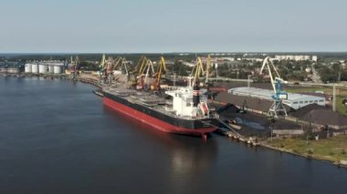 Ventspils, Letonya - Temmuz 2019: Ventspils limanındaki büyük kuru kargo gemisi ve gemi vinçlerinin hava aracı görüntüsü.