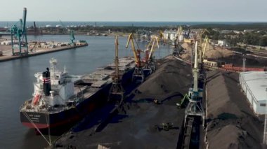 Ventspils, Letonya - Temmuz 2019: Kargoyu kuru kargo gemisine yükleyen iskele tarafındaki vinç görüntüsü.