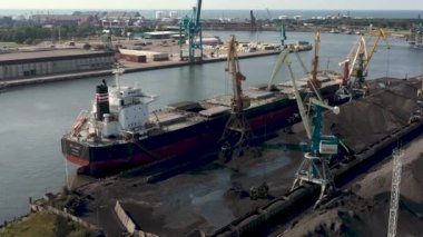 Ventspils, Letonya - Temmuz 2019: Kargoyu kuru kargo gemisine yükleyen iskele tarafındaki vinç görüntüsü.