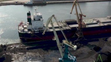 Ventspils, Letonya - Temmuz 2019: Ventspils limanındaki kargo gemisine kargo yükleyen iskele vinç görüntüsü.