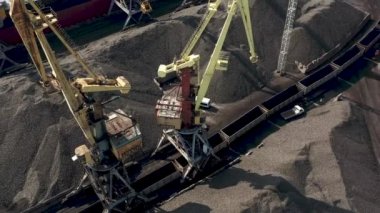Ventspils, Letonya - Temmuz 2019: Kargoyu kuru kargo gemisi ve demiryolu vagonuna yükleyen iskele vinç görüntüsü.