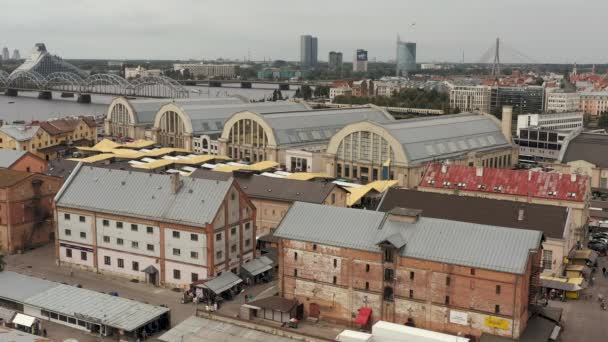 Riga, Lettország - 2019. május: Légi panoráma a központi piacra Rigában a Daugava folyó közelében, kilátással a hidakra. — Stock videók