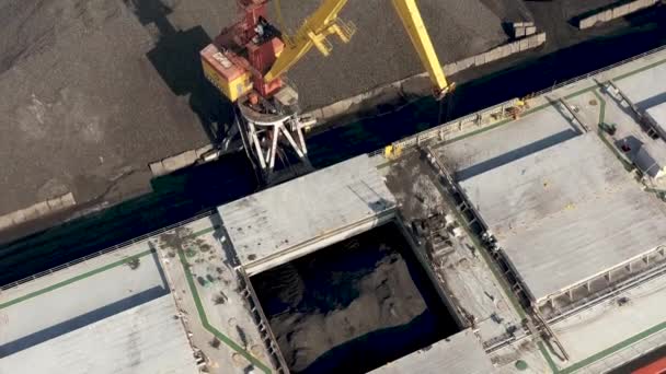 VENTSPILS, LETTONIE - JUILLET 2019 : Vue aérienne de la grue portuaire qui transporte des marchandises à bord d'un cargo sec dans le port de Ventspils . — Video