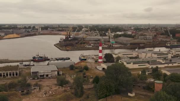 LIEPAJA, LATVIA - JULIO, 2019: Vista aérea del faro en la zona industrial de Liepaja y vista del puerto . — Vídeo de stock