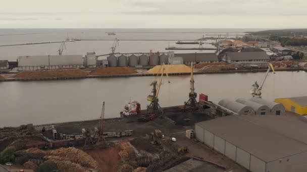 Liepaja, Lettland - Juli 2019: Luftpanorama der Schiffskräne, die im Hafen Fracht in ein Trockenfrachtschiff verladen. — Stockvideo