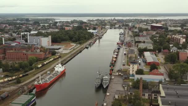LIEPAJA, LATVIA - JULIO, 2019: Vista panorámica aérea de los barcos pesqueros en el canal fluvial por el mar Báltico en Liepaja . — Vídeos de Stock
