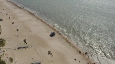 PALANGA, LITHUANIA - JULY, 2019: Aerial flight view of the Baltic sea with waves and white sandy beach in sunny weather.
